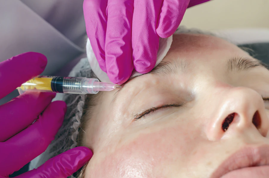 A practitioner administering an anti-wrinkle injection to the forehead